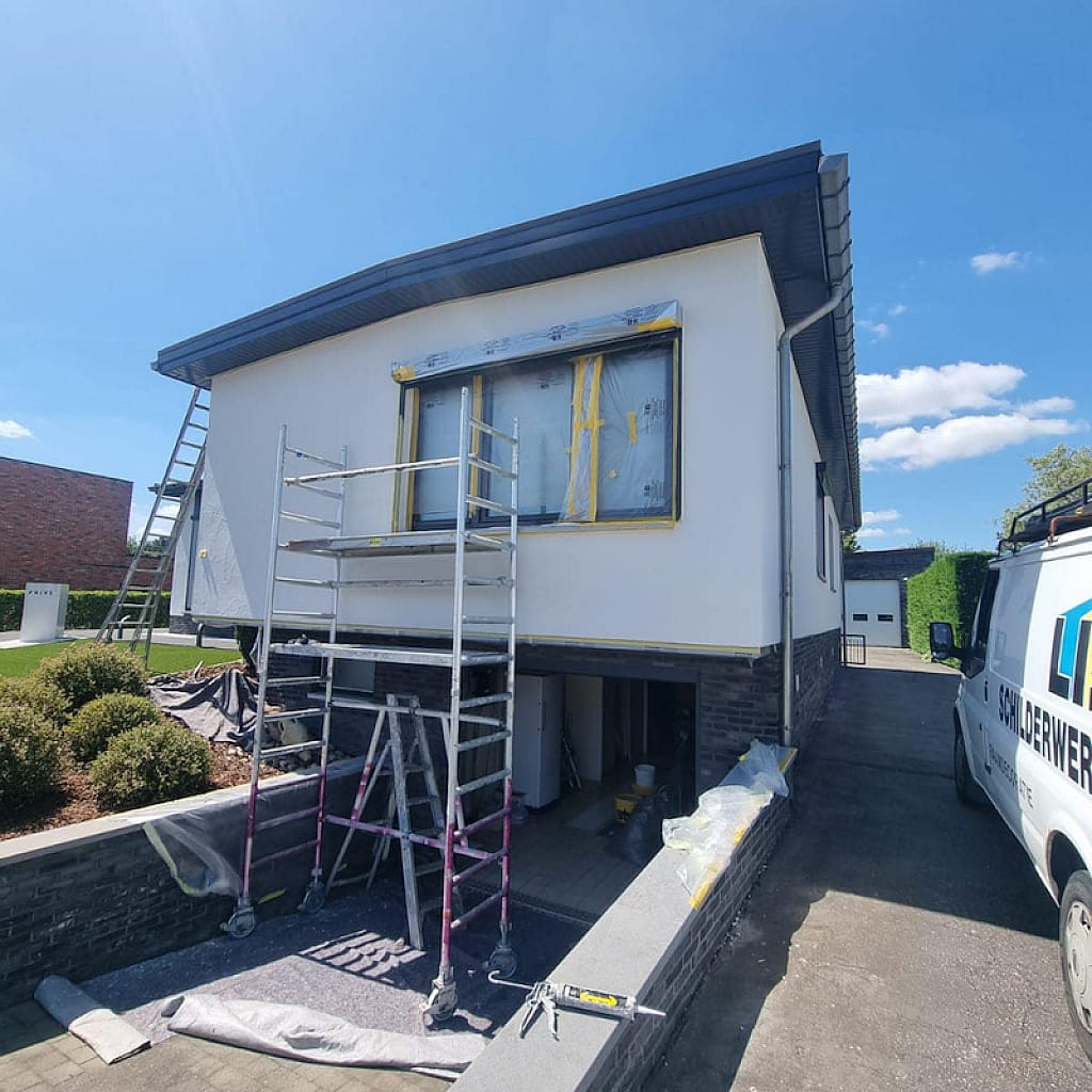 Gevelrenovatie in uitvoering met stelling en de bestelwagen van Lis NV in de kustregio